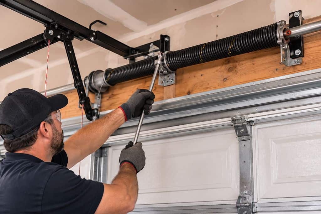 Technician adjusting a garage door torsion spring during residential spring repair in Canoga Park.